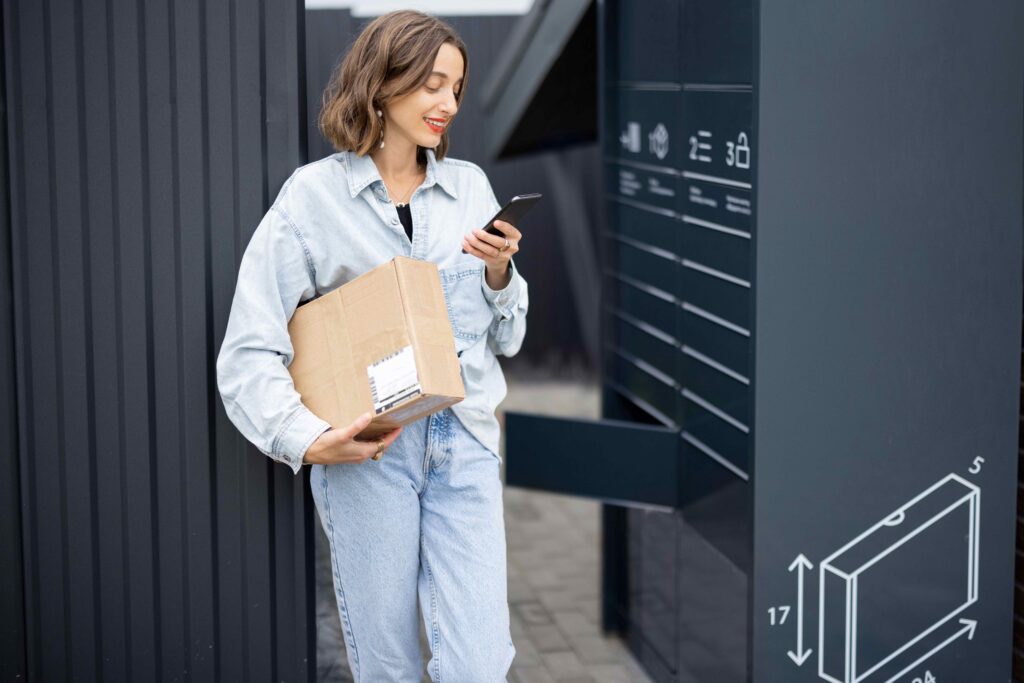 Frau holt ein Paket von einer Packstation ab