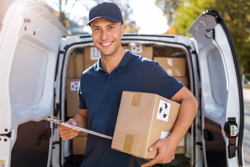 Lieferant mit Paket in der Hand vor Lieferwagen